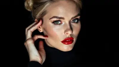 A cinematic close-up portrait of a striking woman in a sleek black turtleneck, her face softly illuminated against a dark, moody background. She has bold matte red lips, dramatic black eyeliner, and defined brows, gazing intensely into the camera with confident, piercing eyes. Her blonde hair is styled in a voluminous, slightly tousled updo, with loose strands framing her flawless, softly contoured face. Her red nails match her lipstick as she gently touches her temple, adding a subtle gesture of elegance. The lighting is clean and high-fashion, creating sharp contrast and rich shadows, evoking the feel of a luxury fragrance campaign, with a minimalist, sophisticated atmosphere, 85mm lens, shallow depth of field, sharp focus on the eyes, cinematic color grading, high-resolution editorial style, no text, no logos.
