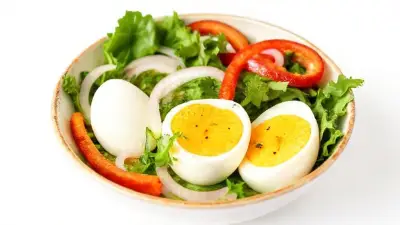 boiled eggs served in a bowl with greens, onions, sliced red peppers, white background, side view, image contains whole bowl