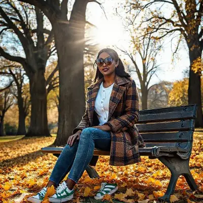 In an autumn park on a sunny day, tall oak trees have shed their leaves, and yellowing leaves lie on the ground. The sun reflects around a woman through the trees. A woman is sitting on a bench. She is in her 30s. She has dark skin, black hair pulled back, and is wearing large oval sunglasses, dark lipstick, and a brown plaid coat. She is wearing a slim-fit white shirt with three buttons undone, skinny jeans, and Puma green and white striped casual shoes. The lighting is suitable for the composition. Camera type: full-frame DSLR 100MP. Lens: 85mm f/1.8 portrait lens. 35mm image;
